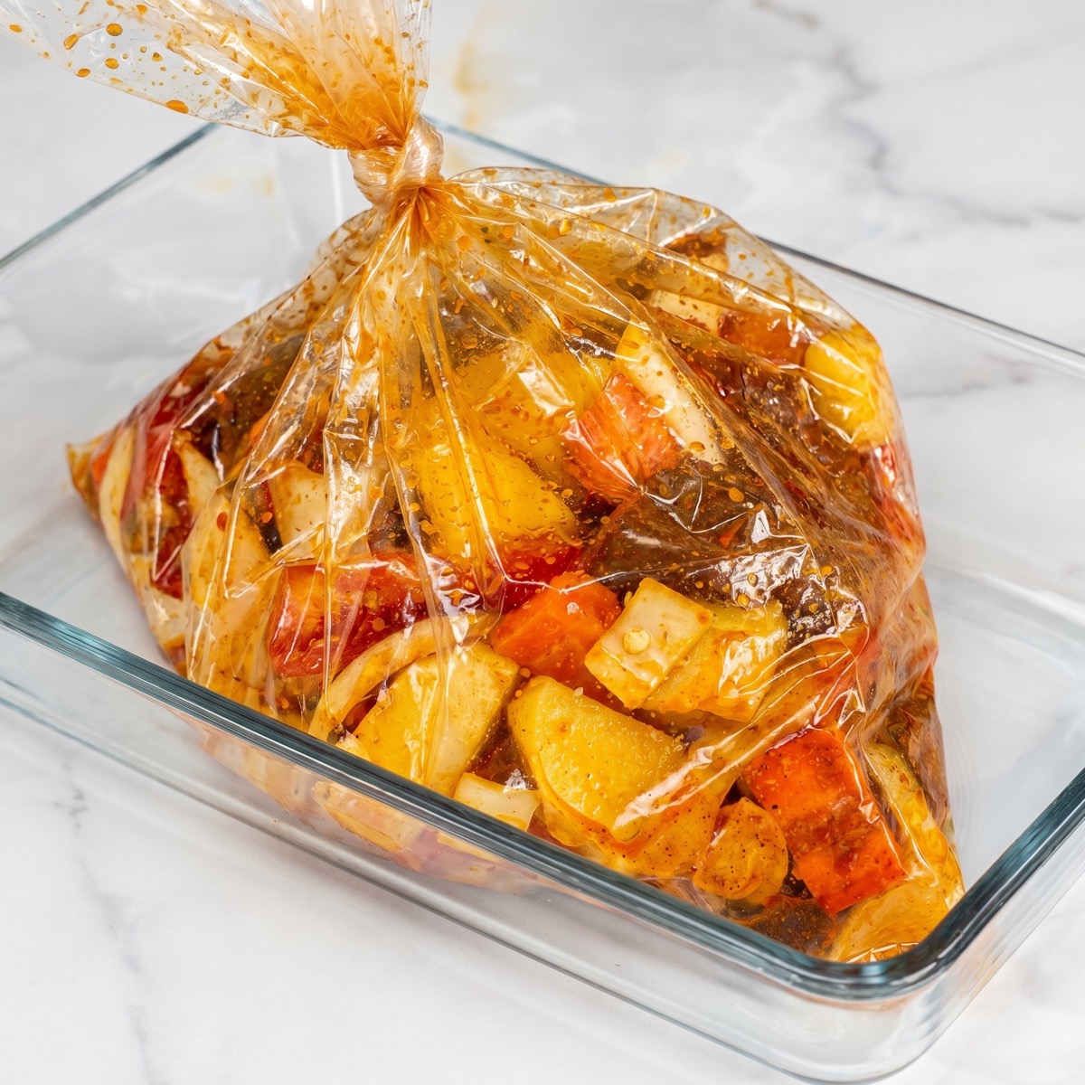 Beef with potatoes, carrots, and bell peppers inside an oven bag.