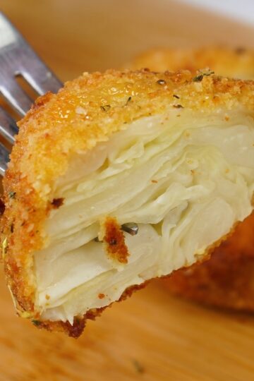Close-up of a crispy fried cabbage steak showing the tender cabbage layers inside.