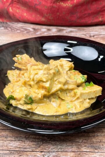 Hähnchen mit cremiger Senfsauce auf einem Teller.