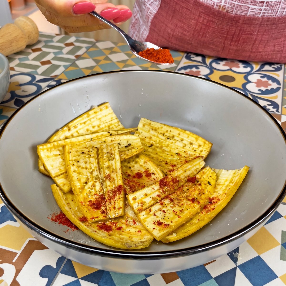 Paprikapulver wird über gewürzte Bananenschalenstücke in einer Schüssel gestreut.