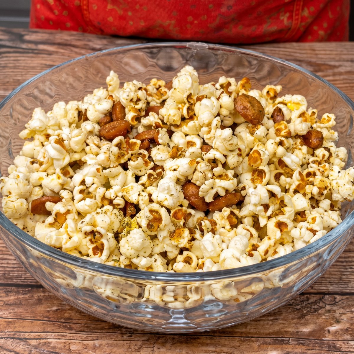 Popcorn mit Würstchenscheiben und Gewürzen in einer Glasschale, servierfertig.
